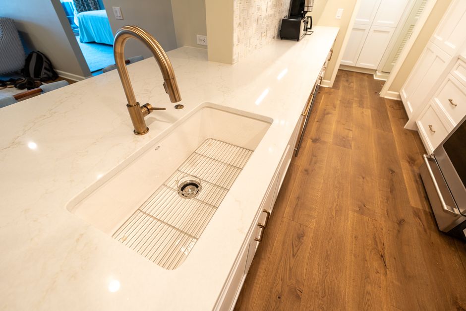 A clean modern kitchen with a marble countertop and sleek fixtures.